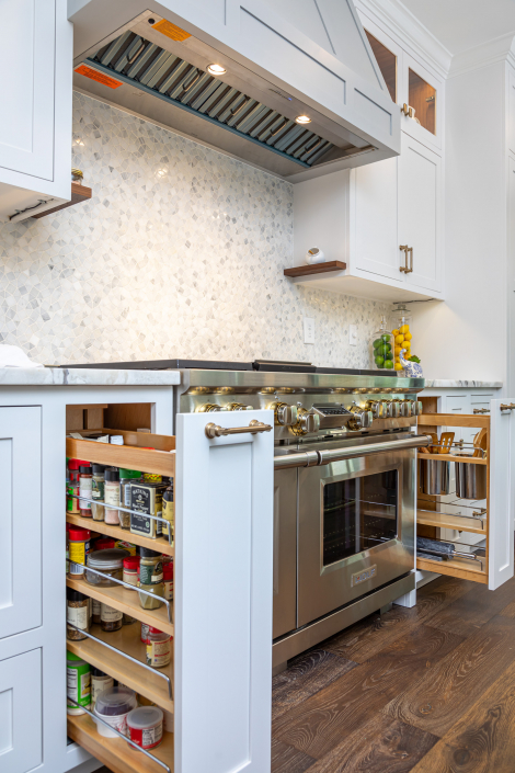 Custom kitchen storage surrounding a professional-grade range featuring built-in pull-out spice racks, utensil organizers, and integrated cooking storage designed for maximum functionality and everyday convenience.