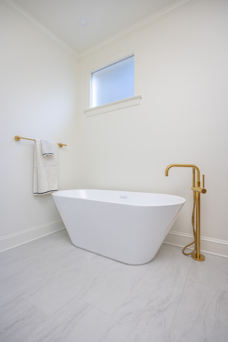 free standing tub with brass tub filler and transom window