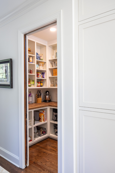 corner pantry storage with wood pocket door