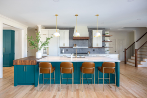 Cary NC kitchen remodel with teal island, gray herringbone tile backsplash, shaker cabinetry, and simple white vent hood with wood accent