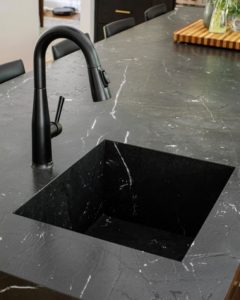 a_23 matte black island countertop with integrated sink and black faucet