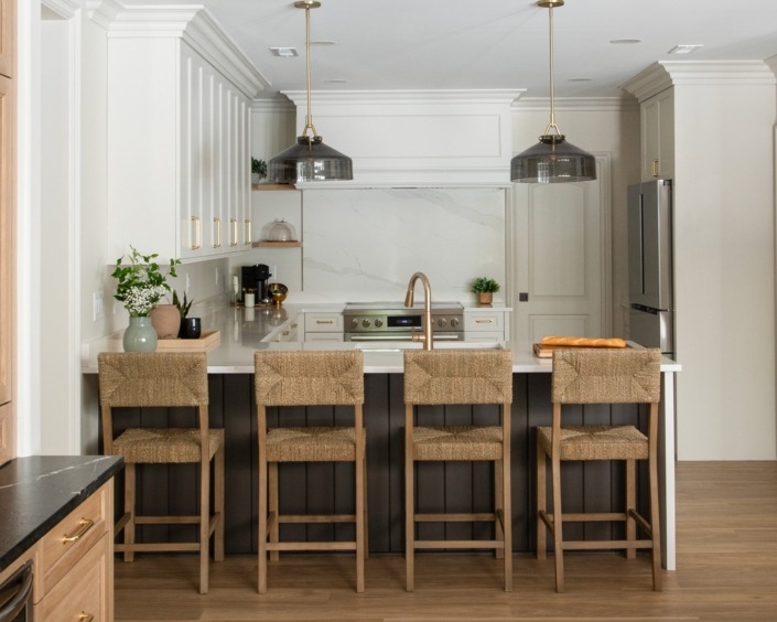 Wakefield_IMG_0001 (2) Basement peninsula kitchen featuring white cabinetry, quartz countertops, open shelving, bar seating, and oversized metal pendant lights.