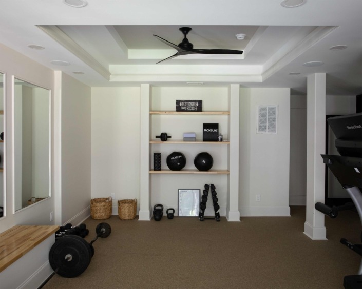 Wakefield_IMG_0005 Bright, high end basement gym with free weights, exercise equipment, custom storage, and a detailed coffered ceiling.