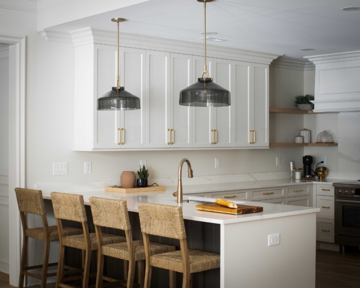 Wakefield_IMG_0011 Basement kitchen featuring white cabinetry, quartz countertops, open shelving, bar seating, and oversized metal pendant lights.