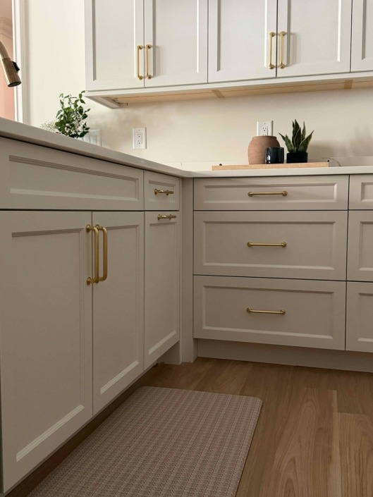 wakefield IMG_1466 Custom warm white cabinetry with brass hardware, quartz countertops, and functional drawer storage.